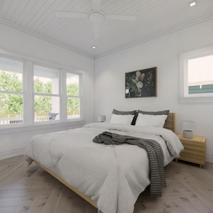 May include: A bright, airy bedroom with a light wood bed frame and matching nightstand. The bed is covered with a white comforter and a gray throw blanket. A floral painting hangs above the bed, and a large window provides natural light.