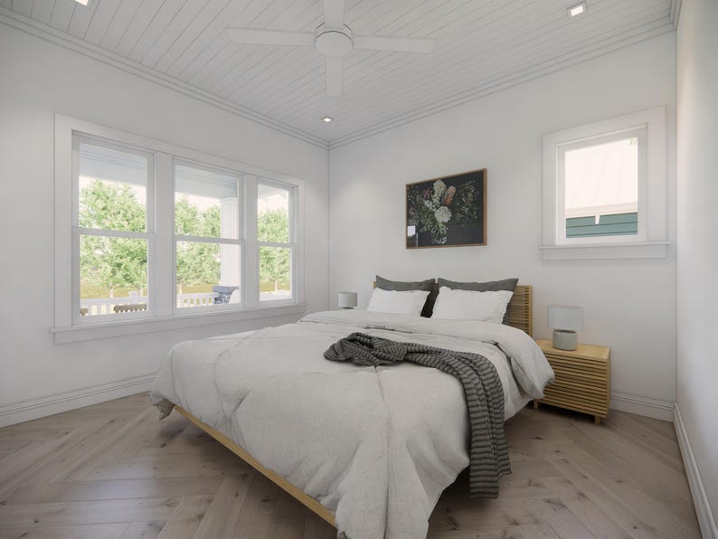 May include: A bright, airy bedroom with a light wood bed frame and matching nightstand. The bed is covered with a white comforter and a gray throw blanket. A floral painting hangs above the bed, and a large window provides natural light.