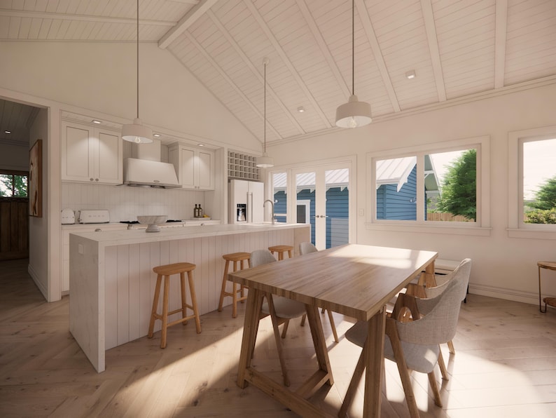 May include: Bright, airy kitchen and dining area with white cabinetry, a large island, and a wooden dining table. The room features a vaulted ceiling, pendant lights, and large windows offering natural light. Wooden stools and chairs complete the space.