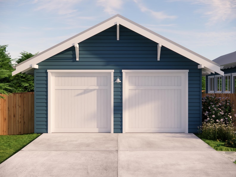 May include: A two-car garage with a navy blue exterior and white trim. The garage doors are white, and a small light fixture is mounted between them. The roof is white, and the driveway is concrete.