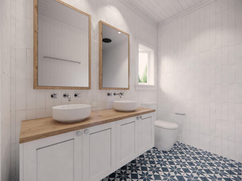 May include: A modern bathroom with white walls and a blue and white patterned tile floor. The room features two mirrors with wooden frames, two white sinks, and a white cabinet with a wooden countertop. A white toilet is also visible.