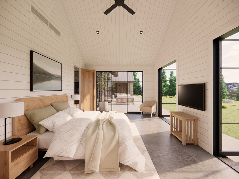 Interior shot of the master bedroom in Mill Farm, a home design by Turnervisual. The walls are clad in white shiplap and the floor is polished concrete. A large king sized bed is in the center of the room and is underlaid by a rug.