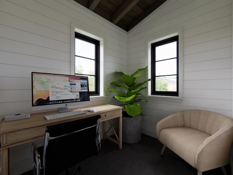 May include: A home office with a wooden desk, black chair, and a computer monitor displaying a colorful interface. A potted plant sits near a window, and a beige loveseat is in the corner. The walls are white with black window frames.