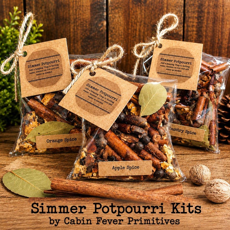 May include: Three clear plastic bags filled with simmer potpourri, each featuring a brown paper tag tied with twine. The tags are labeled Simmer Potpourri, Orange Spice, Apple Spice, and Country Spice. The bags contain cinnamon sticks and leaves.