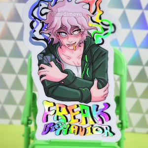 Puede incluir: Pegatina holográfica de vinilo con un personaje de estilo anime con pelo rosa y una chaqueta verde. La pegatina tiene el texto "FREAK BEHAVIOR" en letras coloridas. La pegatina también tiene el texto "Komaeda Holographic Vinyl Sticker".