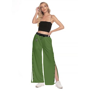 May include: Green wide-leg pants with a black waistband and a heart-shaped design on the left leg. The pants have a side slit on each leg and button detailing along the sides.
