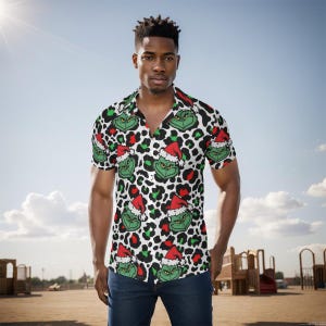 Puede incluir: Camisa de manga corta con un estampado del Grinch y gorro de Papá Noel sobre un fondo de estampado de leopardo blanco y negro. La camisa tiene cuello de campamento y se usa con vaqueros azules. La imagen está tomada al aire libre en un día soleado.