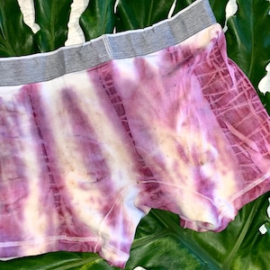 Puede incluir: Bóxers de color morado y blanco con estampado tie-dye y cintura gris.