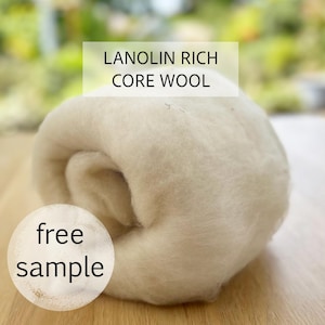May include: A close-up of a roll of off-white core wool. The text "LANOLIN RICH CORE WOOL" is displayed in a white rectangle above the wool. A white circle with the words "free sample" is in the lower left corner.