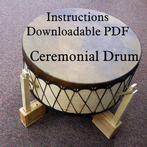 May include: A brown ceremonial drum with black lacing and wooden legs. The drum is on a brown carpet. The text "Instructions Downloadable PDF Ceremonial Drum" is written on the drum.