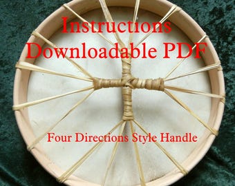 Pode incluir: Um close-up de um tambor de moldura de madeira com uma cabeça de couro natural. O tambor está sendo amarrado com um cordão de fibra natural. O texto "Instructions Downloadable PDF" e "Four Directions Style Handle" está impresso em vermelho no tambor.