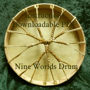 May include: A close-up of a Nine Worlds Drum with a natural leather drumhead and a woven rawhide lacing system. The text "Instruction Downloadable PDF" is printed on the drumhead.