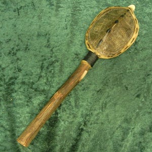 May include: A wooden stick with a leather-covered head, possibly used as a ceremonial or ritual object.
