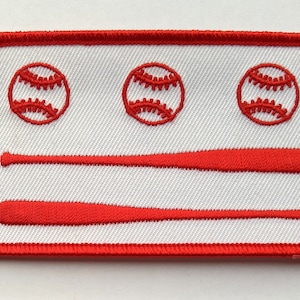 May include: Red, white, and blue embroidered patch with three baseballs and two crossed bats. The patch is surrounded by a red border.