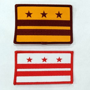 May include: Two embroidered patches featuring the flag of Washington, D.C. The top patch is yellow with three red stars and two red stripes. The bottom patch is white with three red stars and two red stripes.