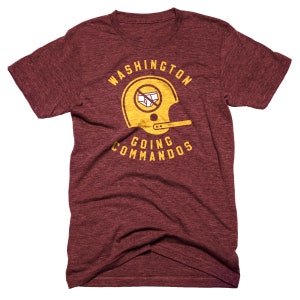 May include: Maroon t-shirt with a distressed gold graphic. The graphic features a football helmet with an image of underwear crossed out, and the text "WASHINGTON GOING COMMANDOS".