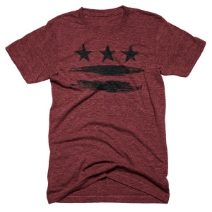 May include: A maroon t-shirt with a black and white graphic of the Washington D.C. flag. The flag features three stars and three horizontal stripes.