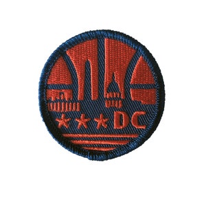 May include: A navy blue and red embroidered patch with a stylized image of the Washington Monument and the text "DC" with three stars.