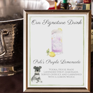 Puede incluir: Un cartel enmarcado con una ilustraci&oacute;n de acuarela de un vaso de limonada morada, un perro peque&ntilde;o y texto que dice "Our Signature Drink Prili's Purple Lemonade Vodka, House Made Lavender Syrup, Lemonade. Served over ice and garnished with a lemon wedge."