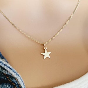 May include: A gold chain necklace with a small, flat, gold star pendant.