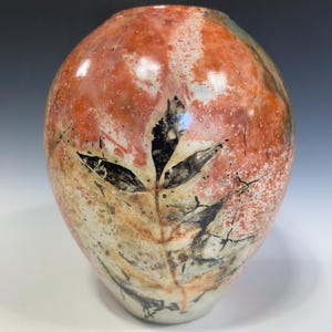 May include: A white ceramic mug with a black handle and the text "But First, Coffee" in a handwritten style. The mug is on a white surface. The mug is 4 inches tall.