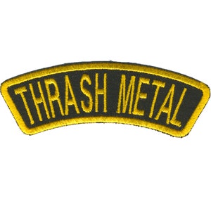 May include: Embroidered patch with the text "THRASH METAL" in yellow, arched across a black background. The patch has a yellow border. The patch is likely for a jacket or bag.