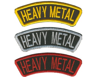 May include: Three embroidered patches with the words "HEAVY METAL" in a curved banner design. The top patch has gold lettering and trim, the middle one has silver, and the bottom one has red.