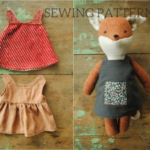 May include: Sewing pattern for a fox doll wearing a gray dress with a floral pocket. The pattern also includes instructions for making two dresses for a doll: one red with white polka dots and one brown.