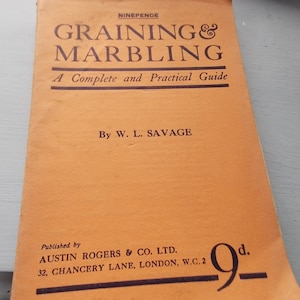 May include: A vintage book cover with the title "Graining & Marbling: A Complete and Practical Guide" by W. L. Savage. The book was published by Austin Rogers & Co. Ltd. in London, England.
