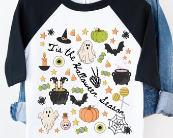 May include: White and black raglan-style Halloween-themed t-shirt. The shirt features various Halloween illustrations, including a witch's hat, pumpkins, ghosts, bats, and the text "Tis the Halloween Season."