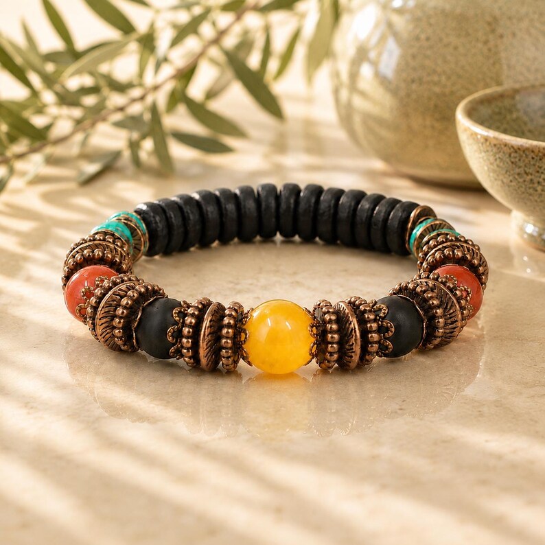 May include: A beaded bracelet featuring a central row of black wooden beads. The bracelet incorporates orange, turquoise, and yellow beads, along with decorative copper-colored metal accents. The bracelet is designed for everyday wear.