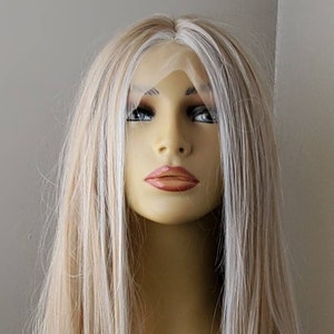 May include: A long, straight, blonde wig with white highlights. The wig is on a mannequin head and is styled in a simple, sleek way.