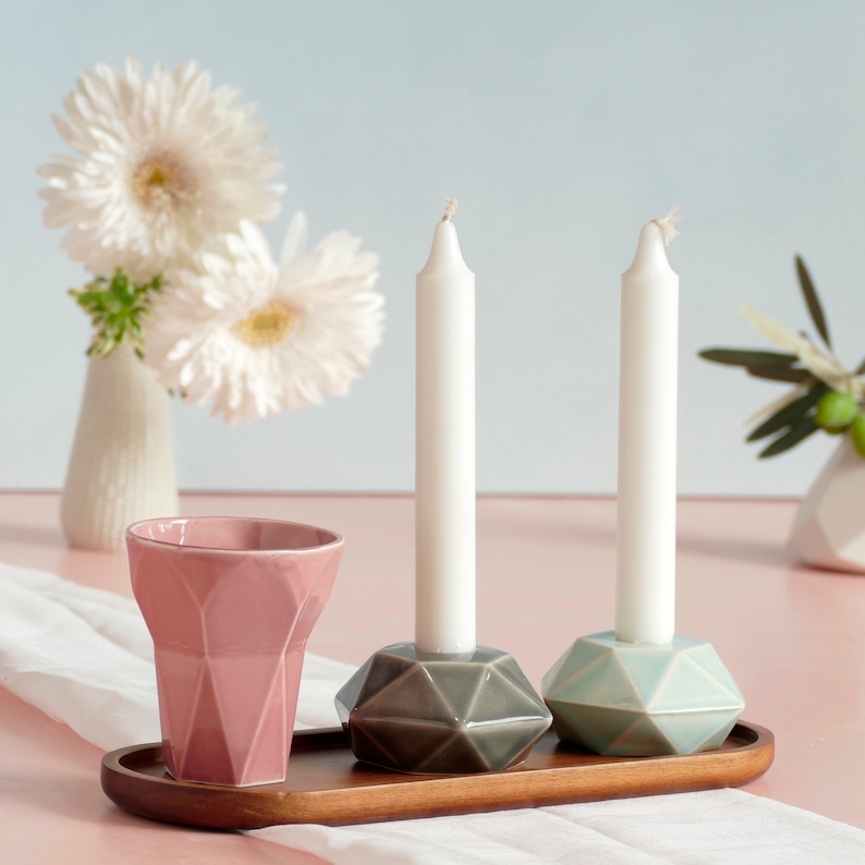 Mystery box of Shabbat table set, includes a Hexagon shaped Kiddush cup and pair of hexagon candlesticks, with matching bamboo tray.

Pictures show different combinations of glazes - the exact colors combination of your set is a surprise.