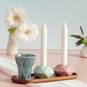 Mystery box of Shabbat table set, includes a Hexagon shaped Kiddush cup and pair of hexagon candlesticks, with matching bamboo tray.

Pictures show different combinations of glazes - the exact colors combination of your set is a surprise.
