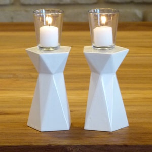 A Pair of elegant Shabbat candlesticks made in Israel and designed in geometric style. These two sided candle holders fit tall celebrative Shabbat candles. The candlesticks are covered in beautiful white glaze.