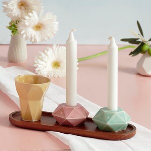 Mystery box of Shabbat table set, includes a Hexagon shaped Kiddush cup and pair of hexagon candlesticks, with matching bamboo tray.

Pictures show different combinations of glazes - the exact colors combination of your set is a surprise.