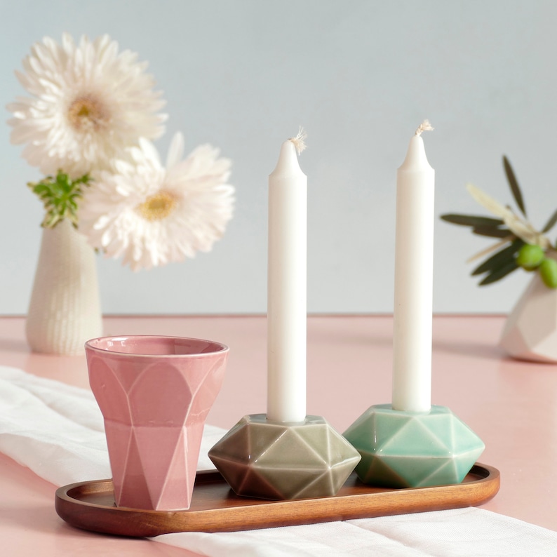 Mystery box of Shabbat table set, includes a Hexagon shaped Kiddush cup and pair of hexagon candlesticks, with matching bamboo tray.

Pictures show different combinations of glazes - the exact colors combination of your set is a surprise.