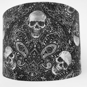 Puede incluir: Pantalla de lámpara en blanco y negro con un patrón de paisley y diseños de calaveras.