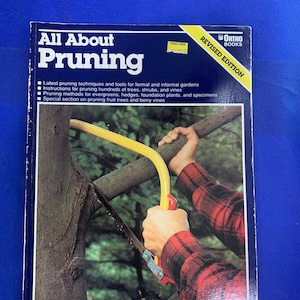 May include: A book titled "All About Pruning" with a blue cover. The cover features a person using a pruning saw on a tree branch. The book is a revised edition and includes information on pruning techniques and tools.