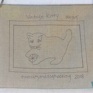 以下が含まれることがあります： ボールで遊ぶ猫の黒い輪郭が描かれたベージュのキャンバス。猫の上に「Vintage Kitty 19x13.5」というテキスト、猫の下に「twocatsanddoghooking 2018」というテキストが書かれている。