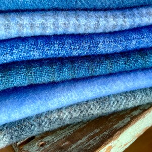 blue wools of different hues and textures piled on a chippy stool