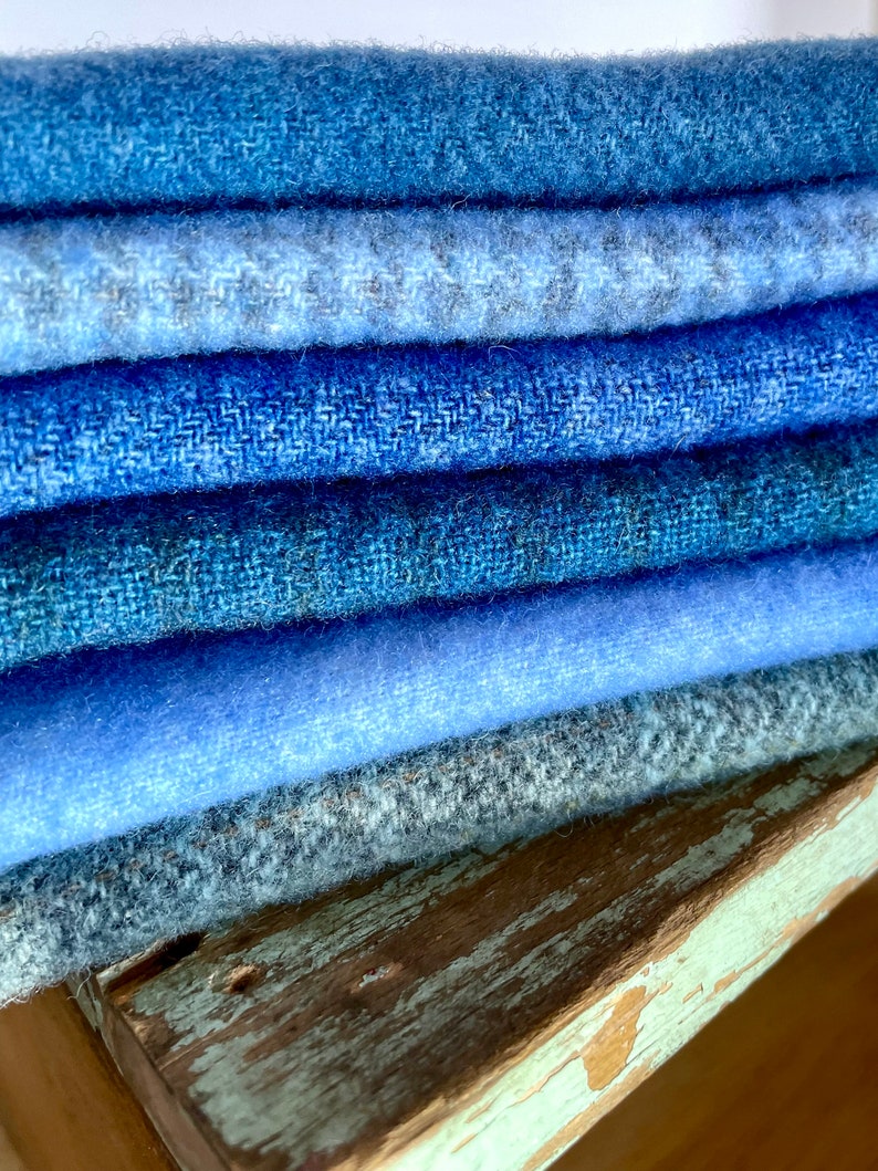 blue wools of different hues and textures piled on a chippy stool