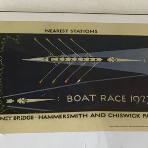 May include: A vintage-style poster titled BOAT RACE 1923 featuring a dark blue background with a rowing shell and oars. The text reads NEAREST STATIONS, BOAT RACE 1923, and PUTNEY BRIDGE HAMMERSMITH AND CHISWICK PARK in a cream-colored border.