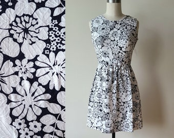 Mini robe mod des années 60 / robe de jardin sans manches en piqué flower power / robe noire et blanche à fleurs avec nœud sur le devant / petite taille