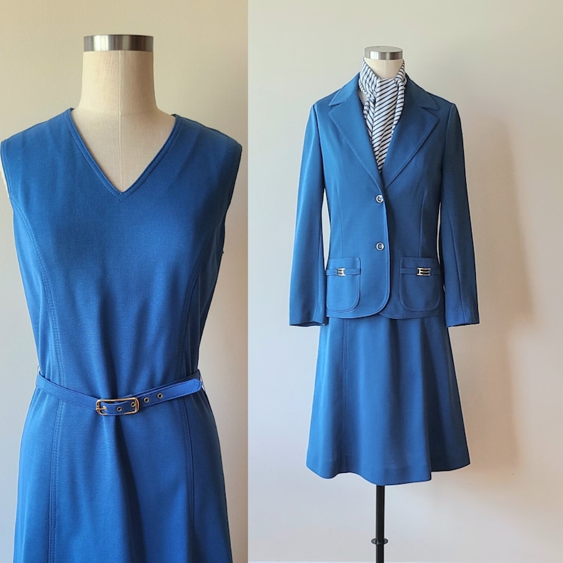 May include: Two vintage teal outfits displayed on mannequins. One is a sleeveless V-neck dress with a matching belt. The other is a skirt suit with a blazer, featuring gold-toned pocket details and a striped scarf.