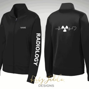 May include: Black zippered jacket with a white radiation symbol and heartbeat graphic on the back. The left sleeve has the word "RADIOLOGY" printed vertically in white. The front of the jacket has a space for a name.