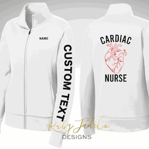 May include: White zippered jacket with the text "CARDIAC NURSE" and a red anatomical heart on the back. The left sleeve has the text "CUSTOM TEXT" and the front has the text "NAME" on the chest.