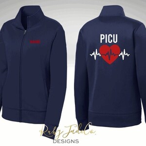 K&ouml;nnte beinhalten: Marineblaue Rei&szlig;verschlussjacke mit einem roten Herzen und einer EKG-Linie auf der R&uuml;ckseite. Der Text "PICU" befindet sich &uuml;ber dem Herzen. Die Vorderseite der Jacke hat den Text "NAME" auf der linken Brust gestickt.
