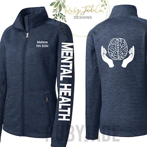 May include: A navy blue fleece jacket with a white brain graphic on the back and the text "MENTAL HEALTH" on the left sleeve. The jacket has a zipper closure and two pockets on the front. The text "Melissa RN BSN" is printed on the left chest.