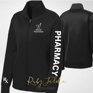 May include: Black zip-up jacket with "PHARMACY" printed vertically on the left sleeve. The jacket features a pharmacy symbol and the text "Stacey Pharmacist" on the chest, and an Rx symbol on the left cuff. The jacket has a full zipper and a stand-up collar.